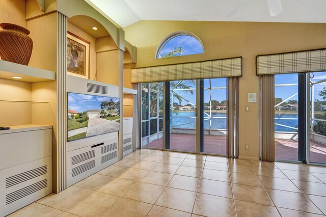 living area with light tile patterned floors and vaulted ceiling