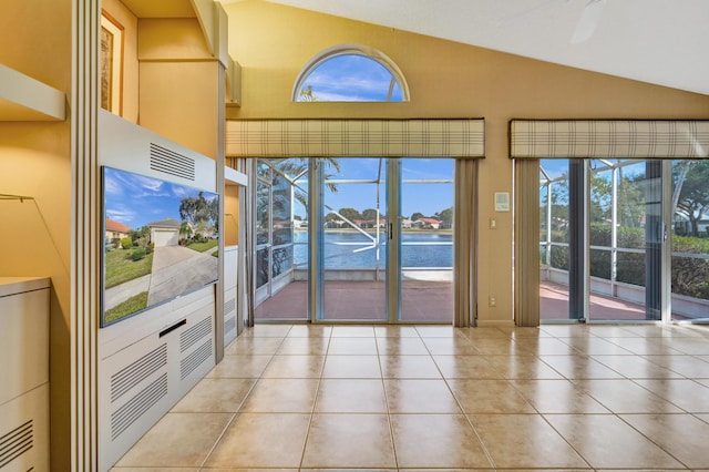 doorway to outside featuring lofted ceiling, tile patterned flooring, and a water view