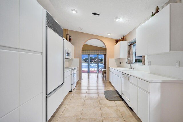 kitchen with sink, white cabinetry, lofted ceiling, white appliances, and hanging light fixtures