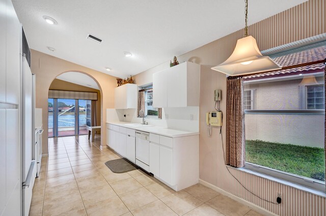 kitchen featuring white appliances, pendant lighting, white cabinetry, light tile patterned flooring, and sink