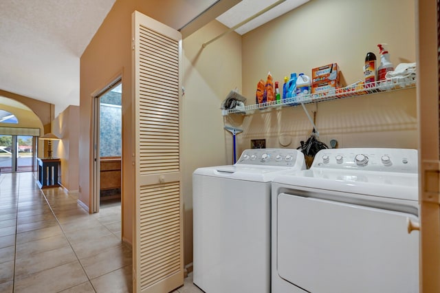 washroom featuring washer and clothes dryer and light tile patterned flooring