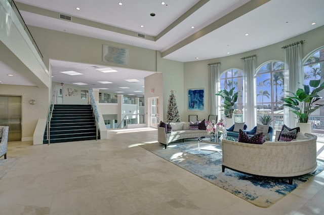 living room featuring elevator and a towering ceiling