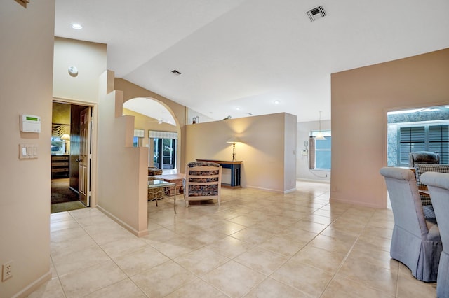 living room featuring ceiling fan, vaulted ceiling, and light tile patterned floors