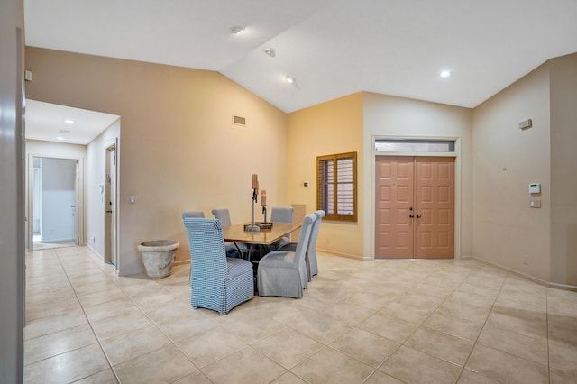 dining room featuring lofted ceiling and light tile patterned flooring