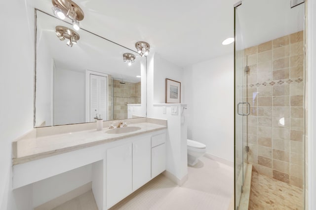 bathroom with an enclosed shower, vanity, toilet, and tile patterned flooring