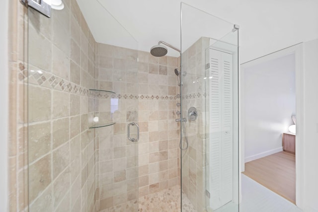 bathroom featuring hardwood / wood-style floors and a shower with shower door