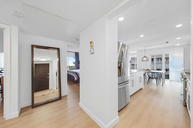 kitchen featuring white cabinets, a healthy amount of sunlight, light hardwood / wood-style floors, and stainless steel appliances