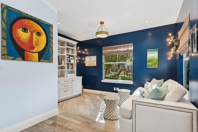 living area featuring built in features and light hardwood / wood-style flooring