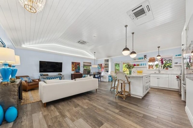 living room featuring wood ceiling, vaulted ceiling, sink, a chandelier, and hardwood / wood-style floors