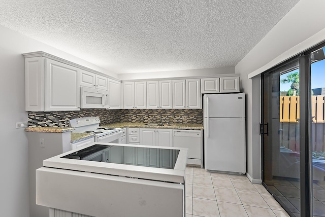 kitchen featuring tasteful backsplash, sink, white cabinets, and white appliances