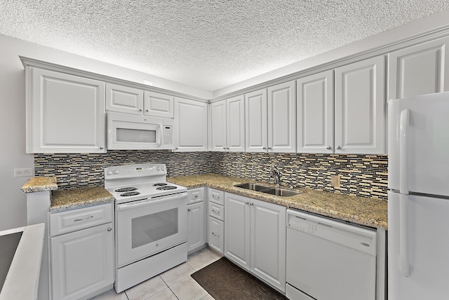 kitchen with white appliances, a textured ceiling, sink, light tile patterned floors, and white cabinetry