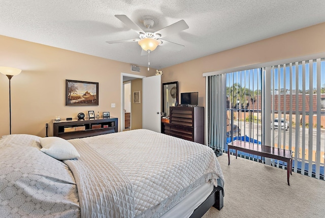 bedroom with ceiling fan, carpet floors, and a textured ceiling