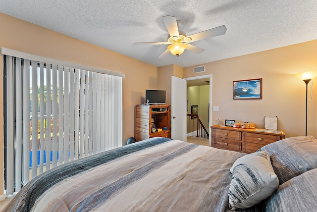 bedroom featuring a textured ceiling and ceiling fan