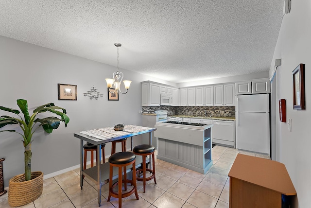 kitchen with pendant lighting, white cabinetry, white appliances, and a textured ceiling