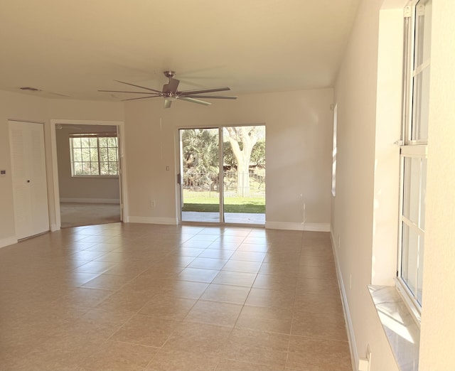 tiled spare room featuring ceiling fan