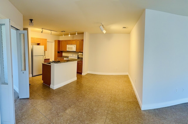 kitchen featuring a kitchen island, track lighting, and white appliances