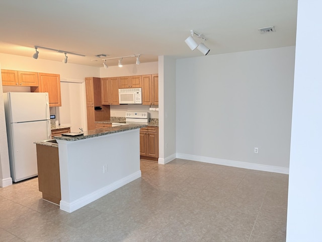 kitchen with a center island, light tile patterned floors, white appliances, and dark stone counters