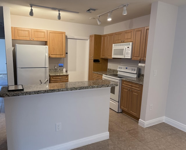 kitchen with light tile patterned floors, white appliances, and a kitchen island