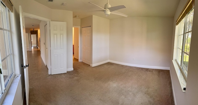 carpeted spare room featuring ceiling fan