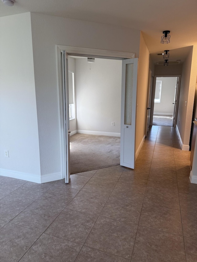 hall with dark tile patterned floors