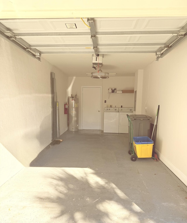 garage with electric water heater and washing machine and clothes dryer