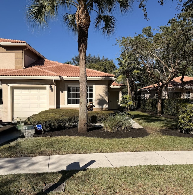 mediterranean / spanish house featuring a front yard and a garage