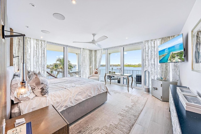 bedroom featuring a wall of windows, light wood-type flooring, access to outside, and ceiling fan