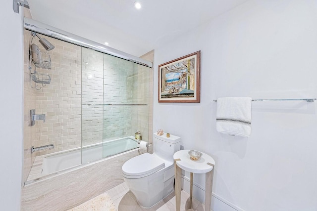 bathroom with shower / bath combination with glass door, tile patterned floors, and toilet