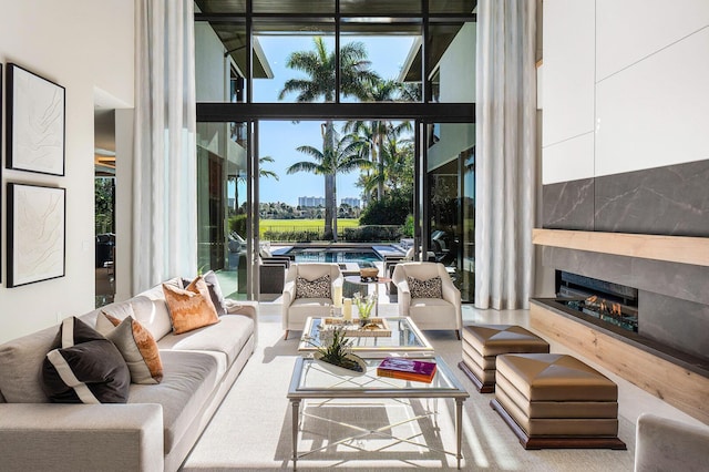 living room with a high end fireplace, floor to ceiling windows, and a high ceiling