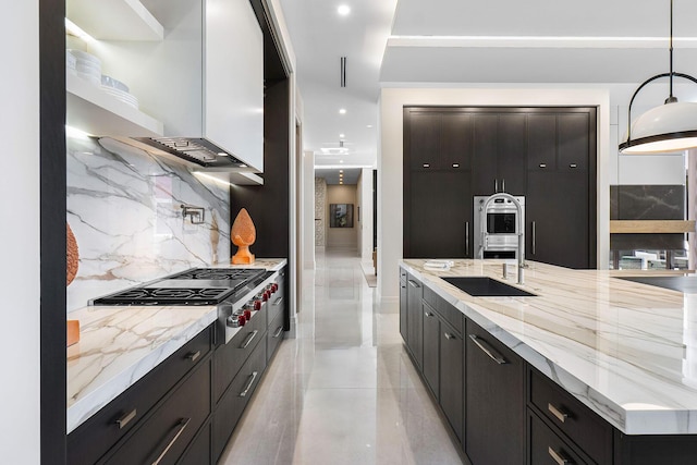 kitchen with light stone countertops, sink, stainless steel appliances, tasteful backsplash, and pendant lighting