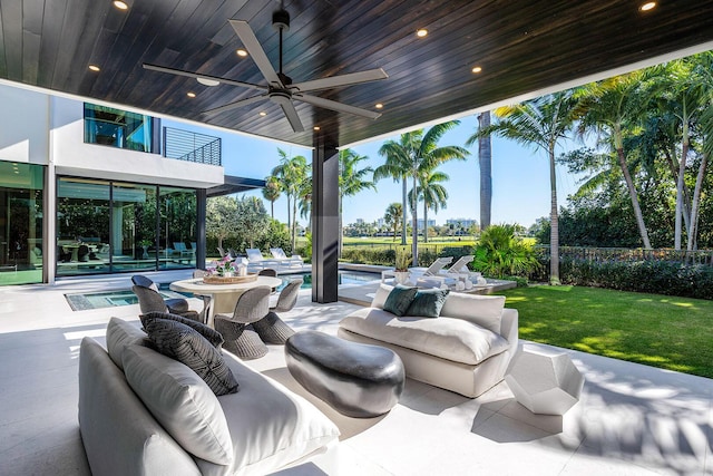 view of patio featuring ceiling fan, a balcony, and an outdoor living space