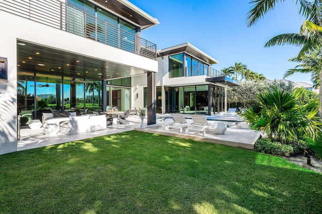 rear view of property with a lawn, a patio area, a balcony, and outdoor lounge area