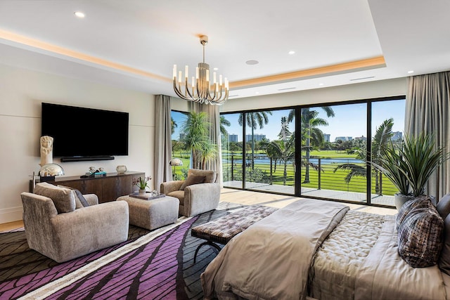 bedroom featuring access to exterior, a raised ceiling, and an inviting chandelier