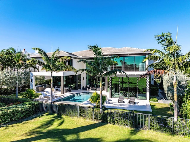 view of pool featuring a yard, a patio, an outdoor hangout area, and exterior kitchen