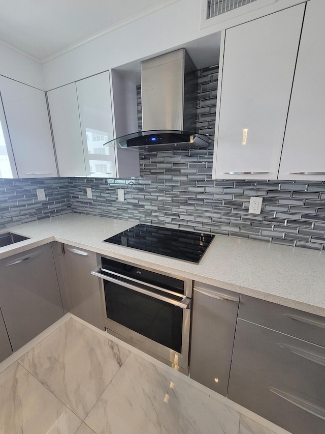 kitchen featuring oven, black electric stovetop, modern cabinets, and wall chimney range hood