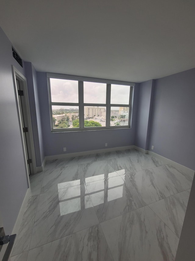 spare room with visible vents, baseboards, and marble finish floor