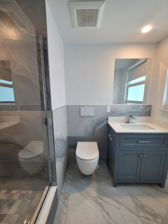 bathroom featuring walk in shower, vanity, toilet, and tile walls