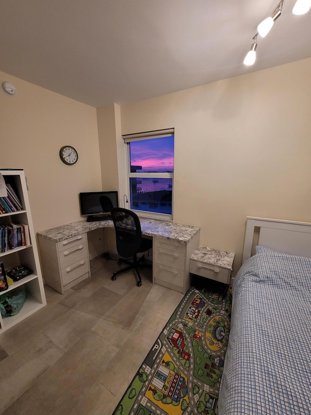 bedroom featuring built in desk and track lighting