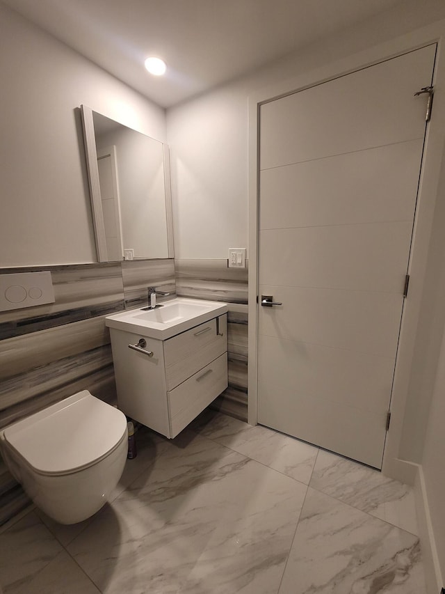 bathroom with toilet, wainscoting, recessed lighting, marble finish floor, and vanity