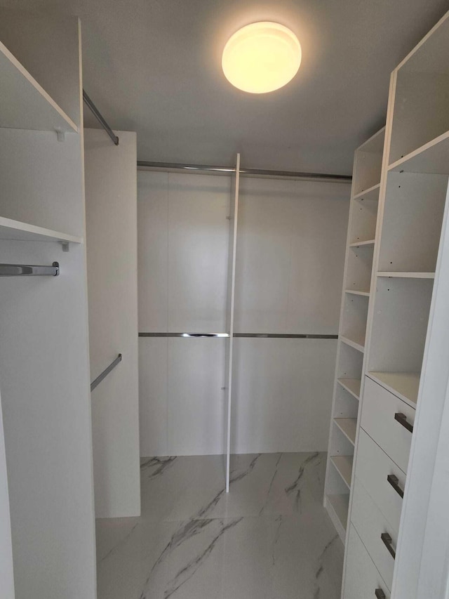 spacious closet with marble finish floor