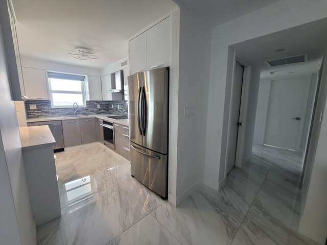 kitchen featuring white cabinetry, black electric cooktop, oven, decorative backsplash, and wall chimney range hood