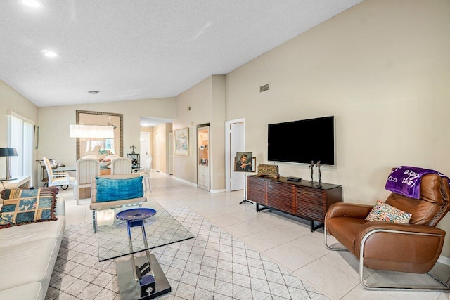 tiled living room featuring lofted ceiling and a textured ceiling