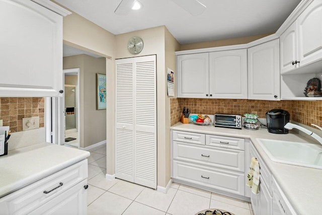 kitchen featuring white cabinets, light tile patterned floors, sink, and tasteful backsplash