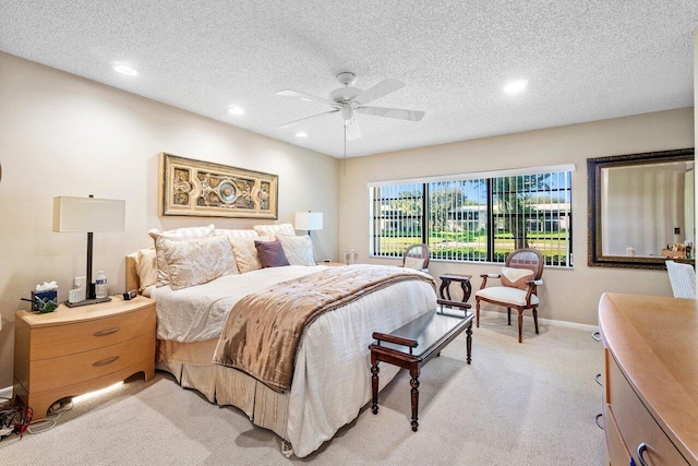 bedroom featuring ceiling fan, light colored carpet, and a textured ceiling