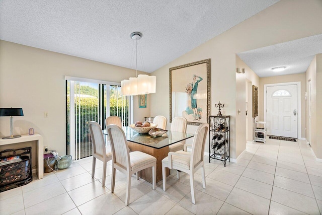 dining space with a textured ceiling, lofted ceiling, and light tile patterned flooring