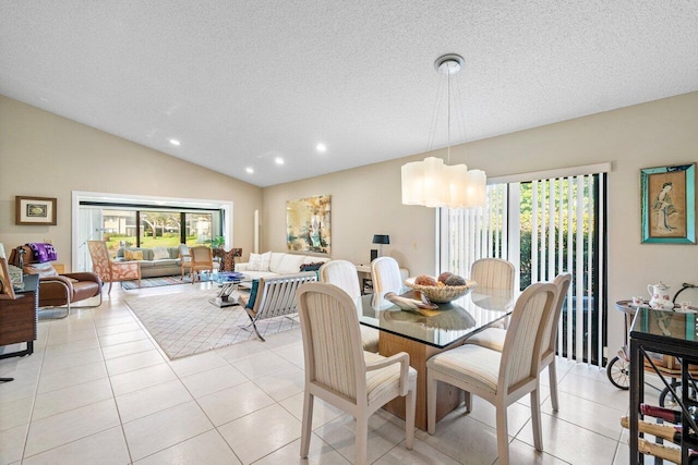 tiled dining area with a notable chandelier, lofted ceiling, and a textured ceiling