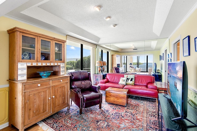 living room featuring a wealth of natural light, crown molding, and a textured ceiling