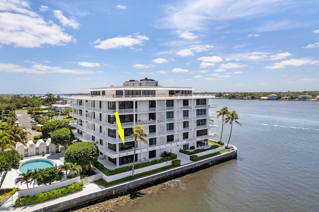 view of building exterior featuring a water view and a community pool