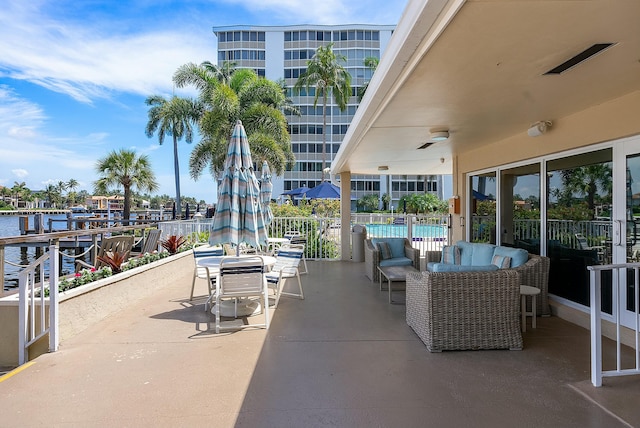 view of patio with a community pool and a water view