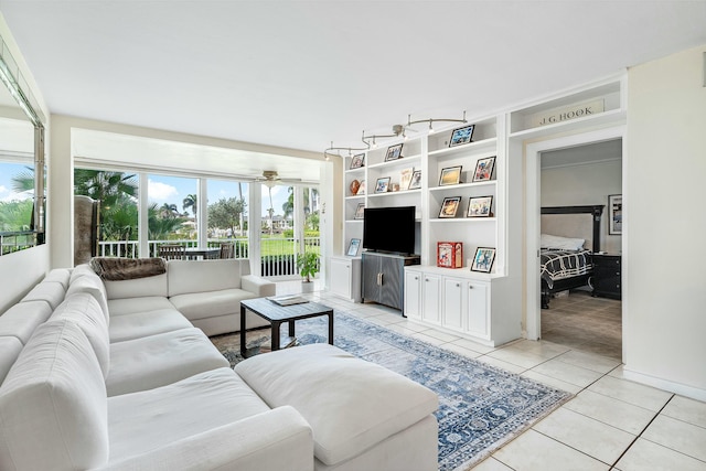 living room featuring ceiling fan, light tile patterned floors, and built in shelves